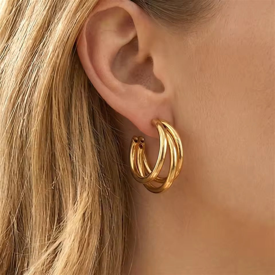 Nærbilde av Chunky Triple Hoop øredobber i 18K gull på modell med blondt hår