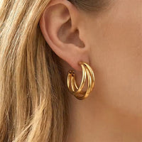 Nærbilde av Chunky Triple Hoop øredobber i 18K gull på modell med blondt hår